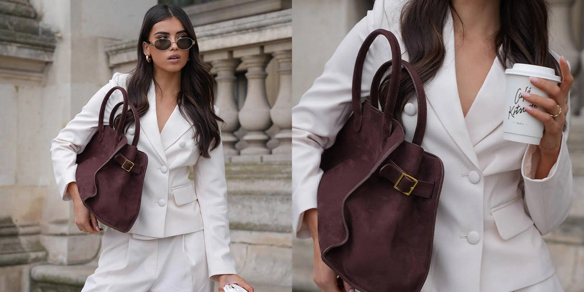 Woman in a white suit carrying a burgundy handbag